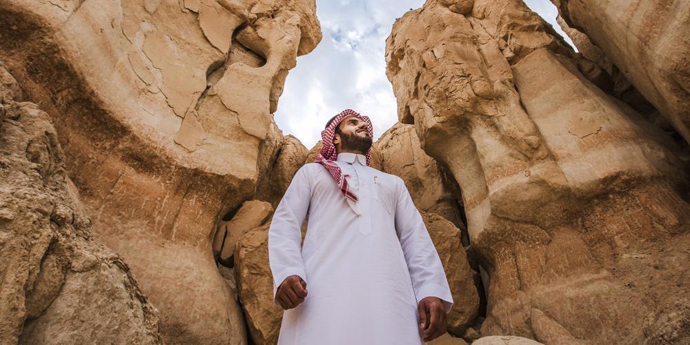 man standing infront of rock mountains